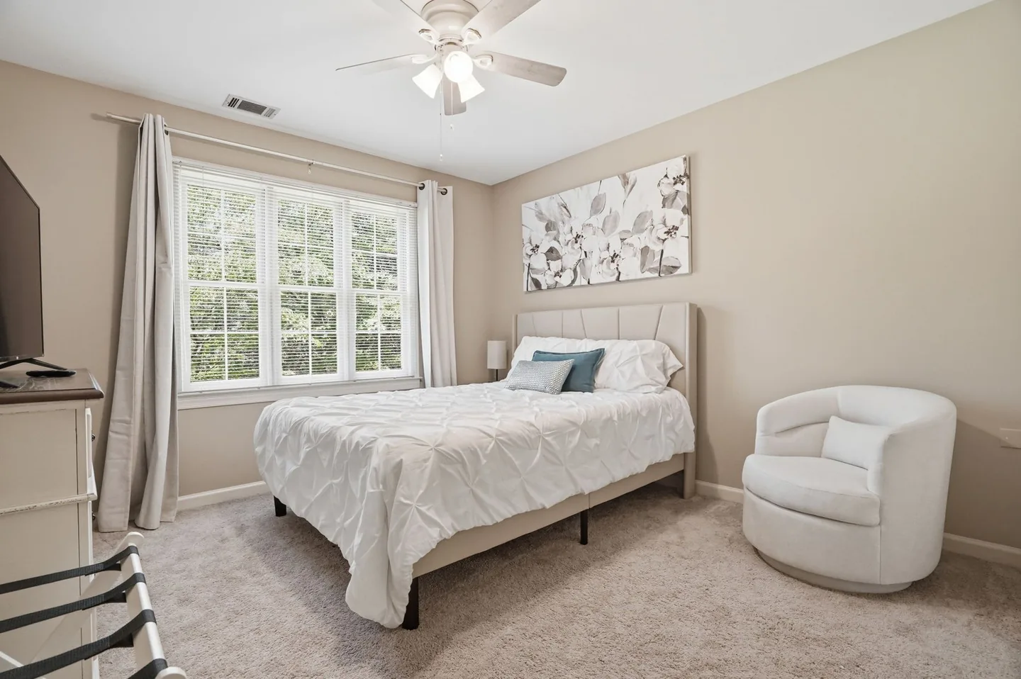 Bedroom with upholstered headboard and accent chair