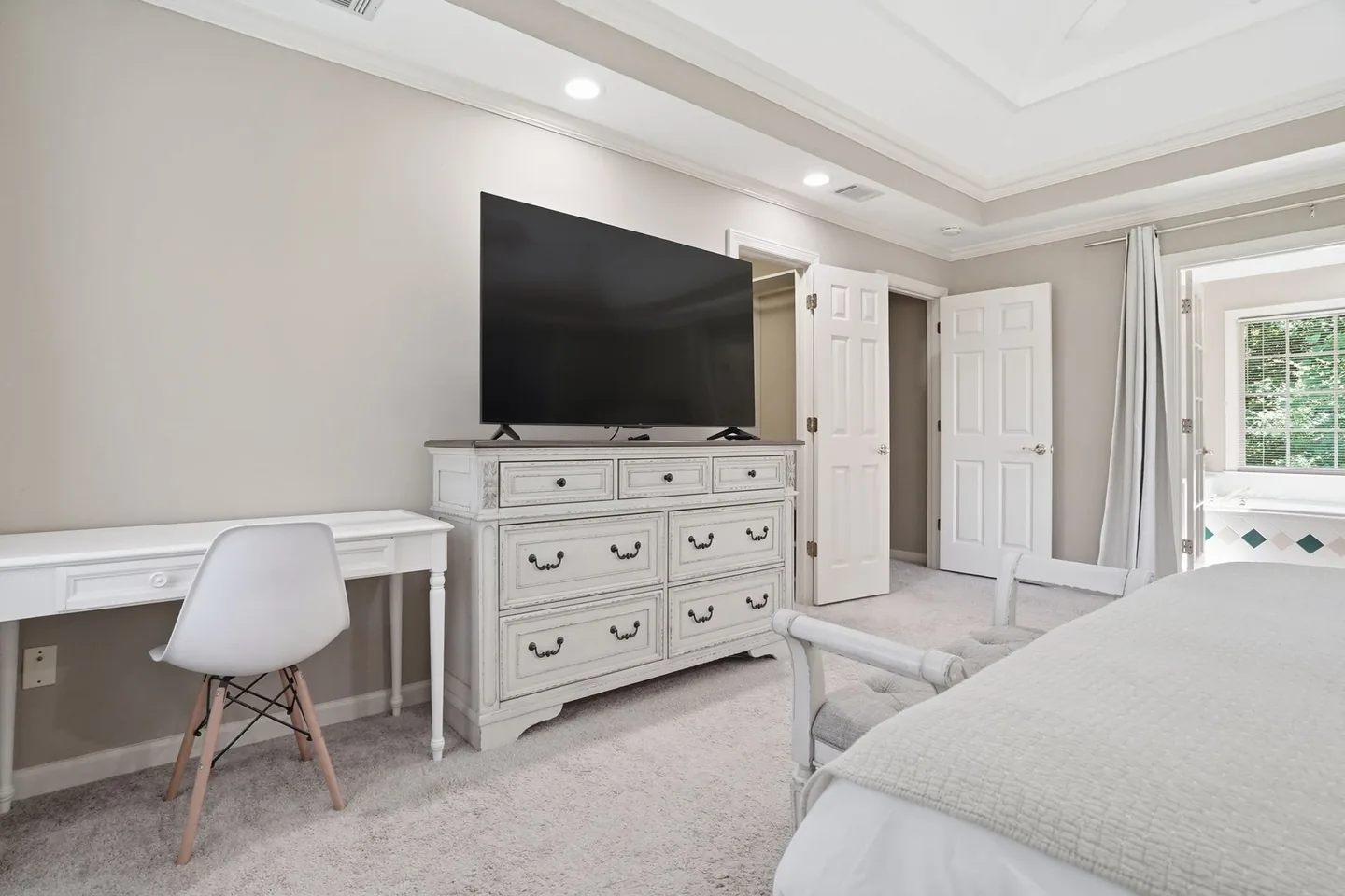 Bedroom with a bed, dresser, and windows
